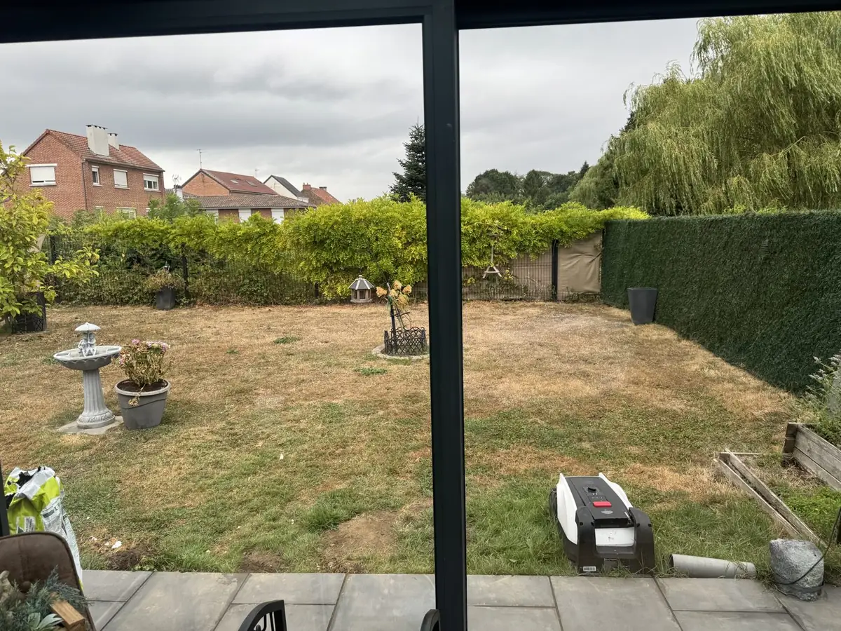 Véranda à Hautmont : baie vitrée nettoyée, vue dégagée sur le jardin