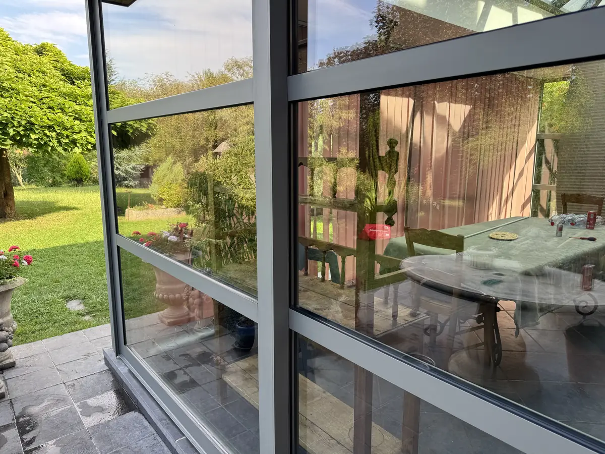 Véranda à Obies : angle vitré nettoyé, vue sur le jardin